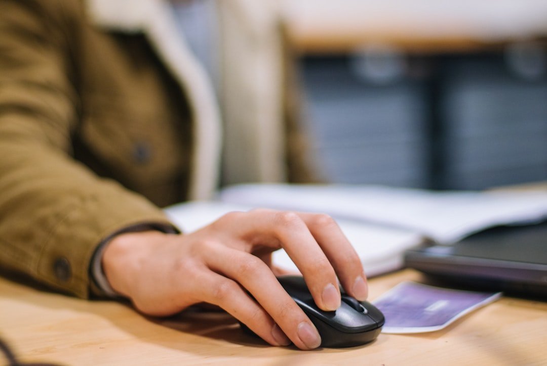 Person holding black cordless computer mouse