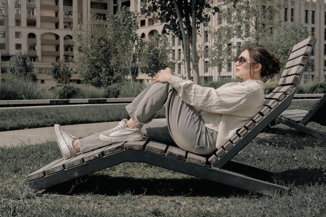 Woman relaxing on a wooden lounge chair outdoors