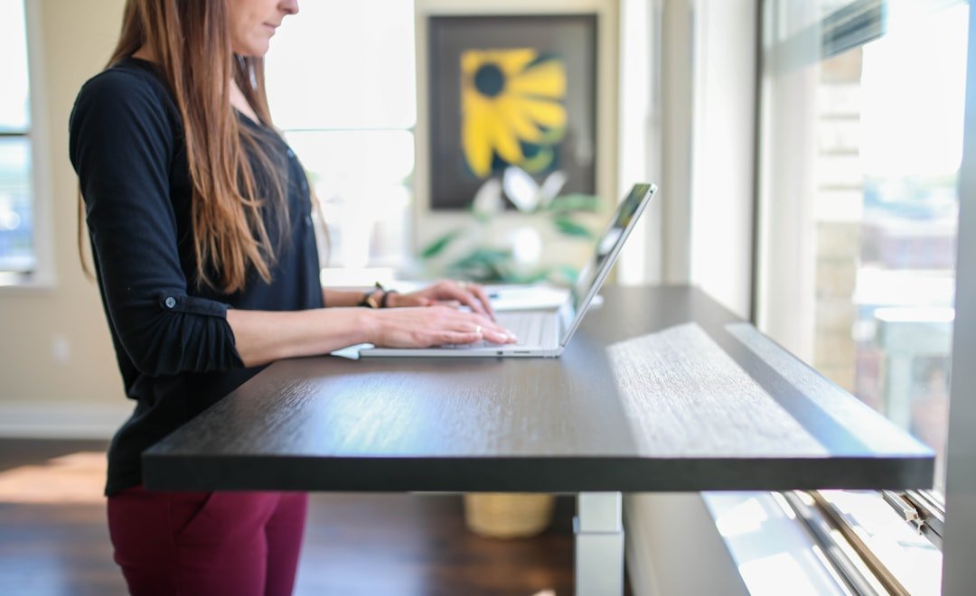 Woman in black shirt sitting at the table using macbook