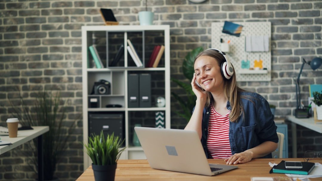 Music help you concentrate: A woman sitting in front of a laptop computer wearing headphones
