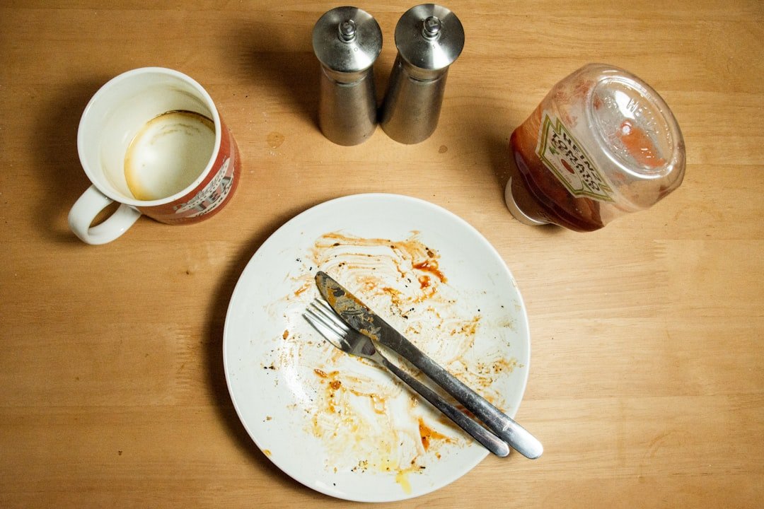 Stainless steel fork and knife on white ceramic plate