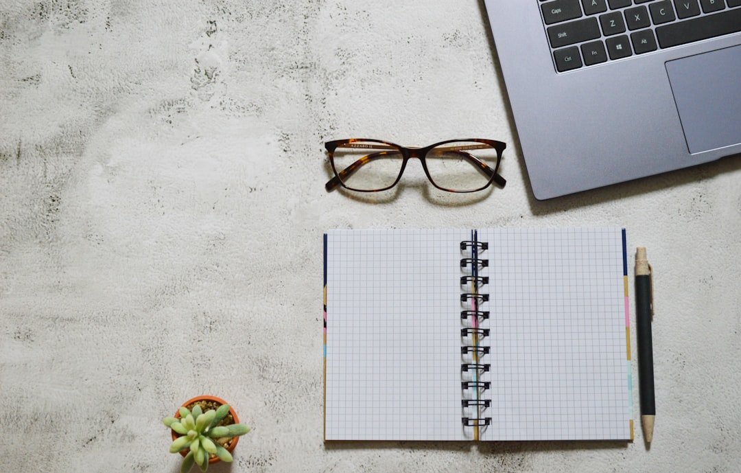 Black framed eyeglasses on white notebook