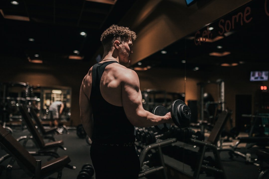 A man holding a dumbbell in a gym