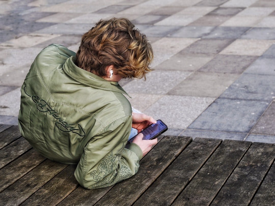 Young person with curly hair using a smartphone
