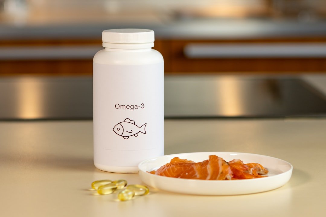 A bowl of fish next to a bottle of vitamins