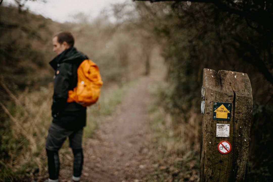 A man with a backpack walking down a path