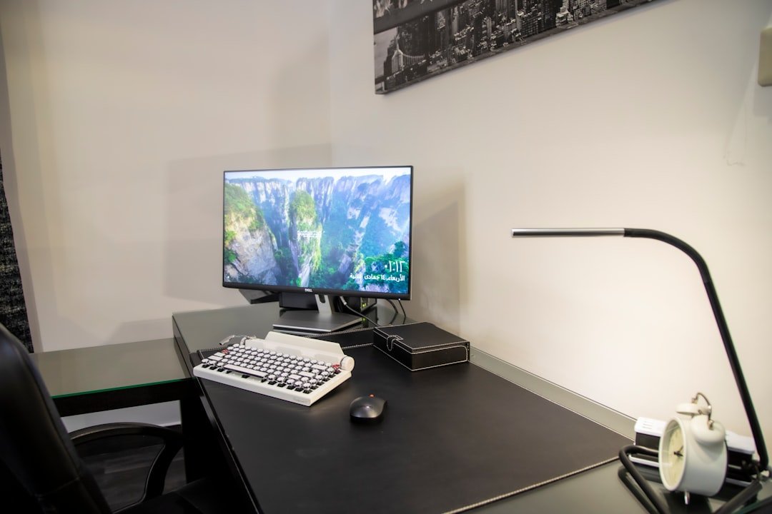 Black flat screen computer monitor on black wooden desk