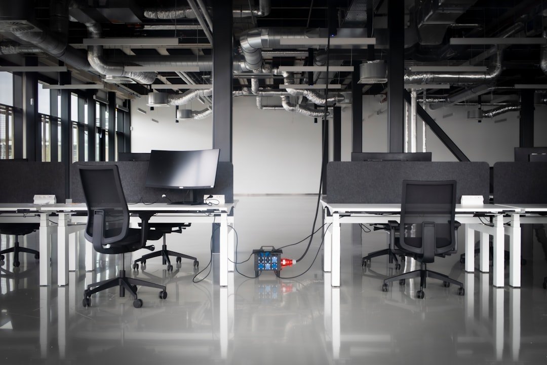 Modern office with desks, chairs, and exposed pipes