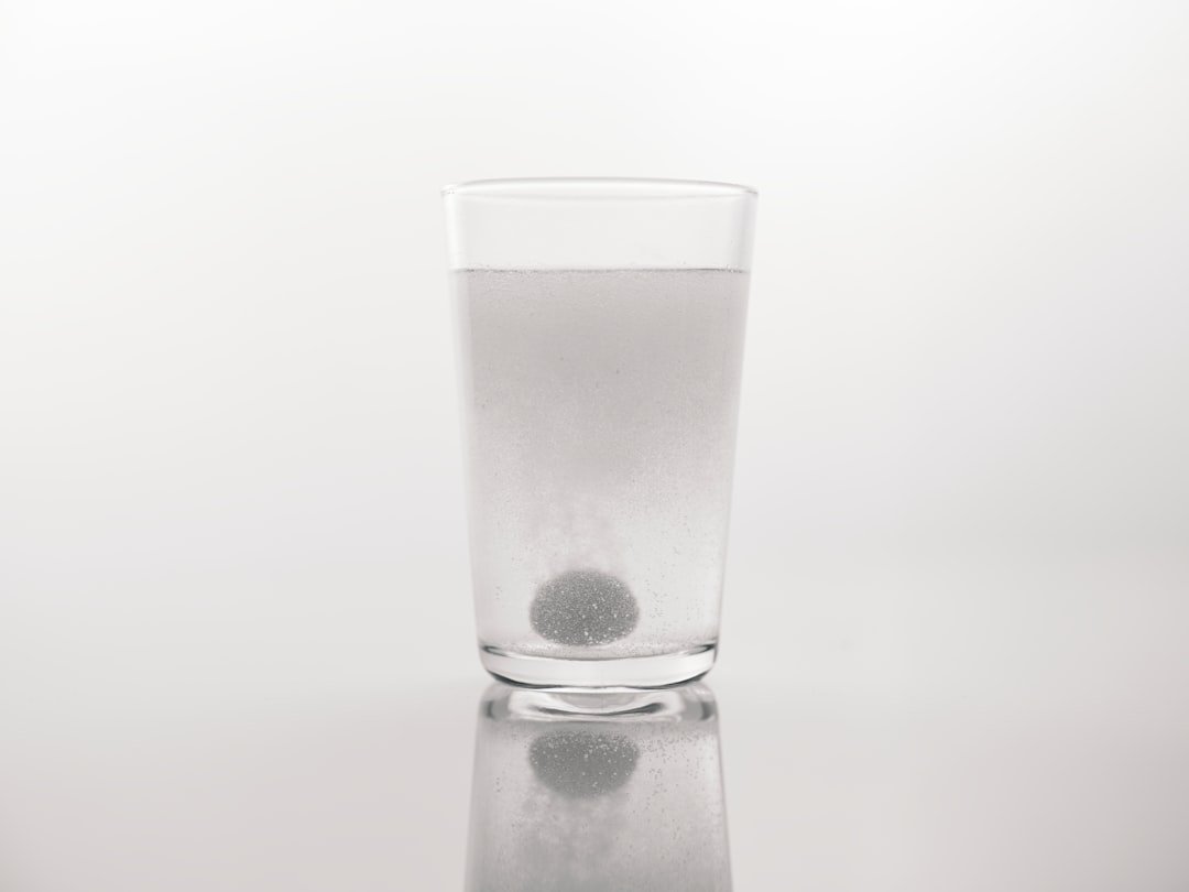 A glass of water with a black dot in it
