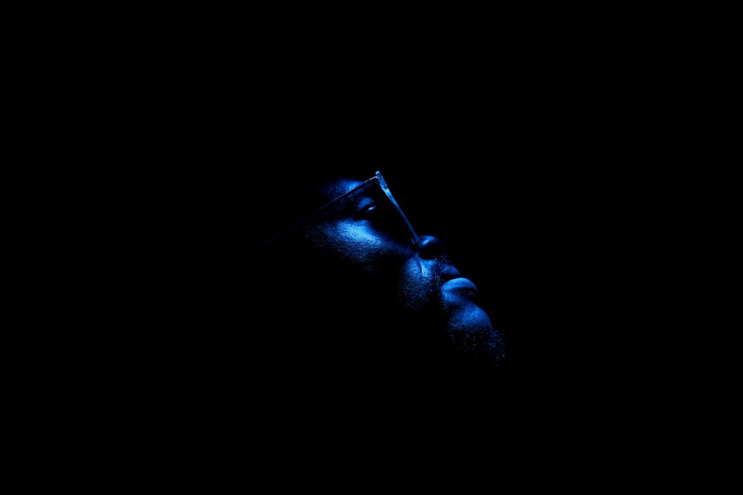 Man wearing eyeglasses in dark room
