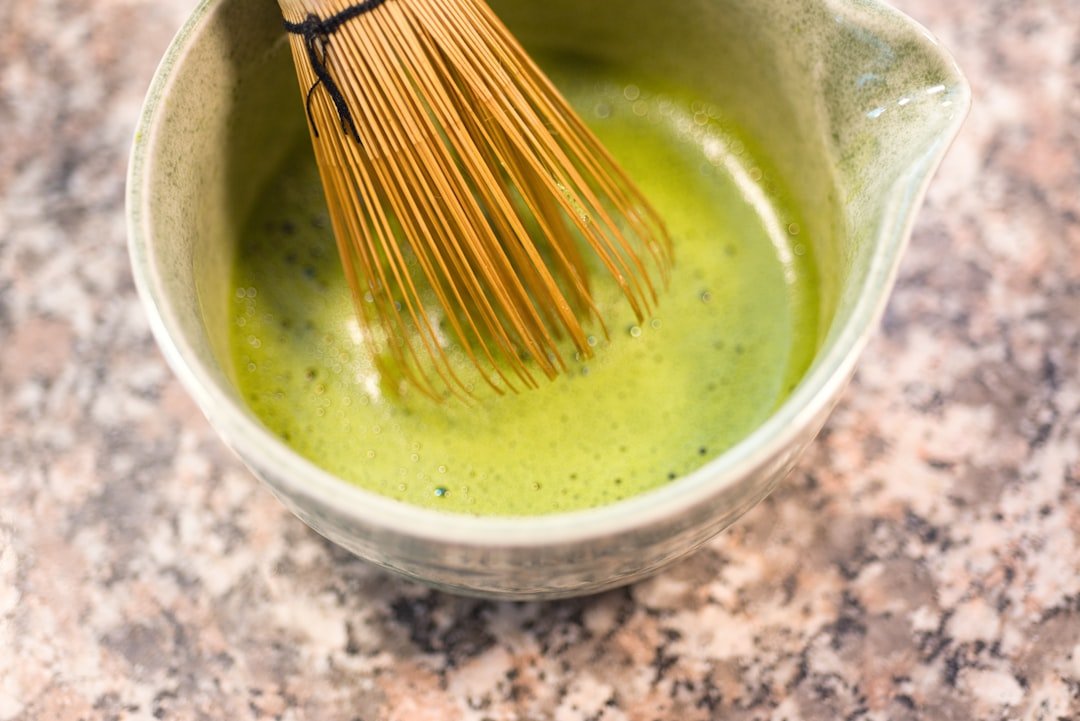 Matcha tea being whisked in a bowl