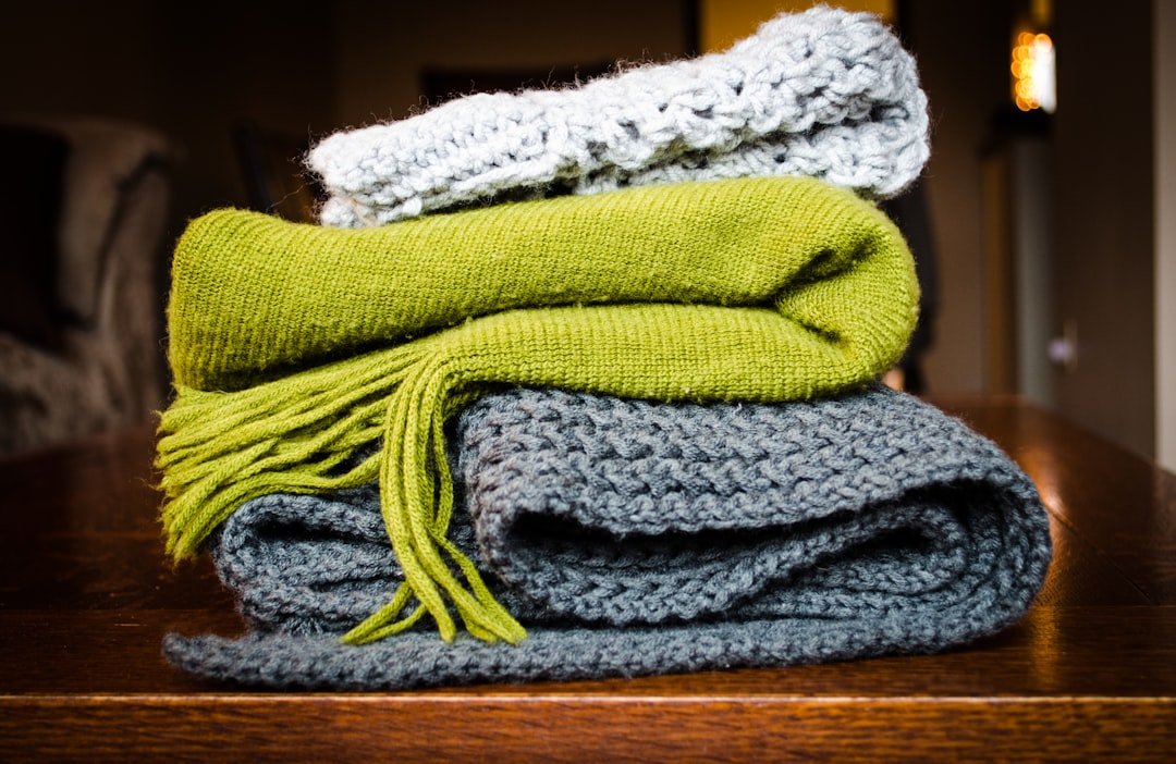 Three gray, green, and white scarf on top of table