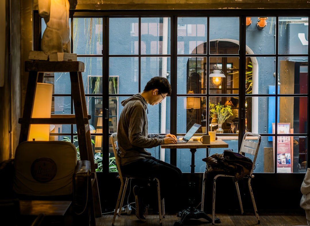 Man working on laptop in a cafe by the window