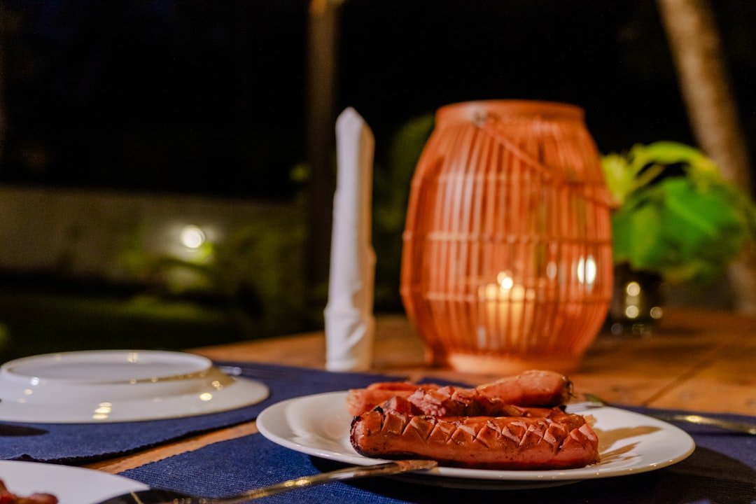 Grilled sausages sit on a dinner table at night