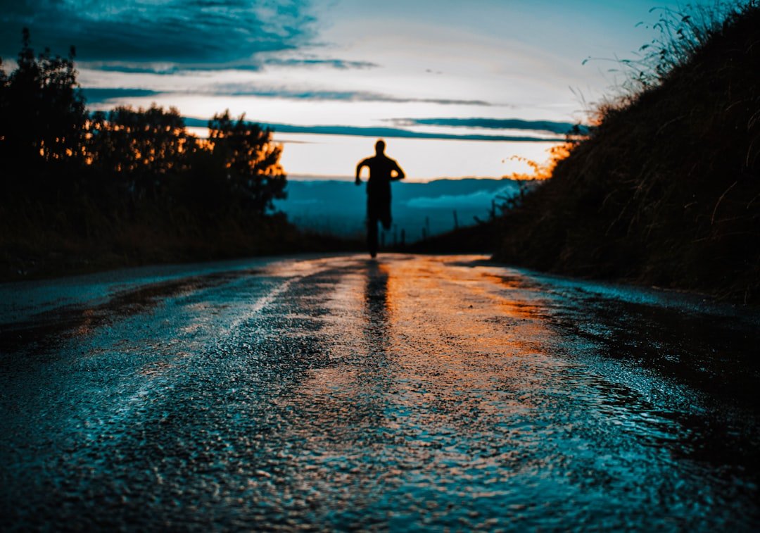 Silhouette photo of a person running on road