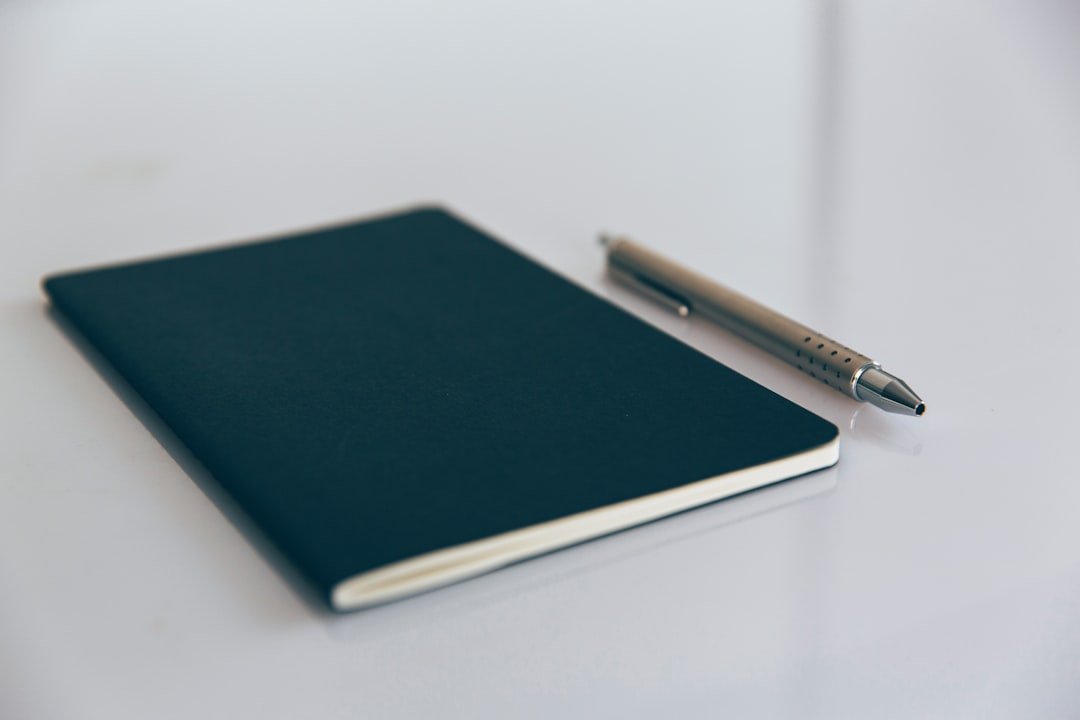 Blue book beside white pen