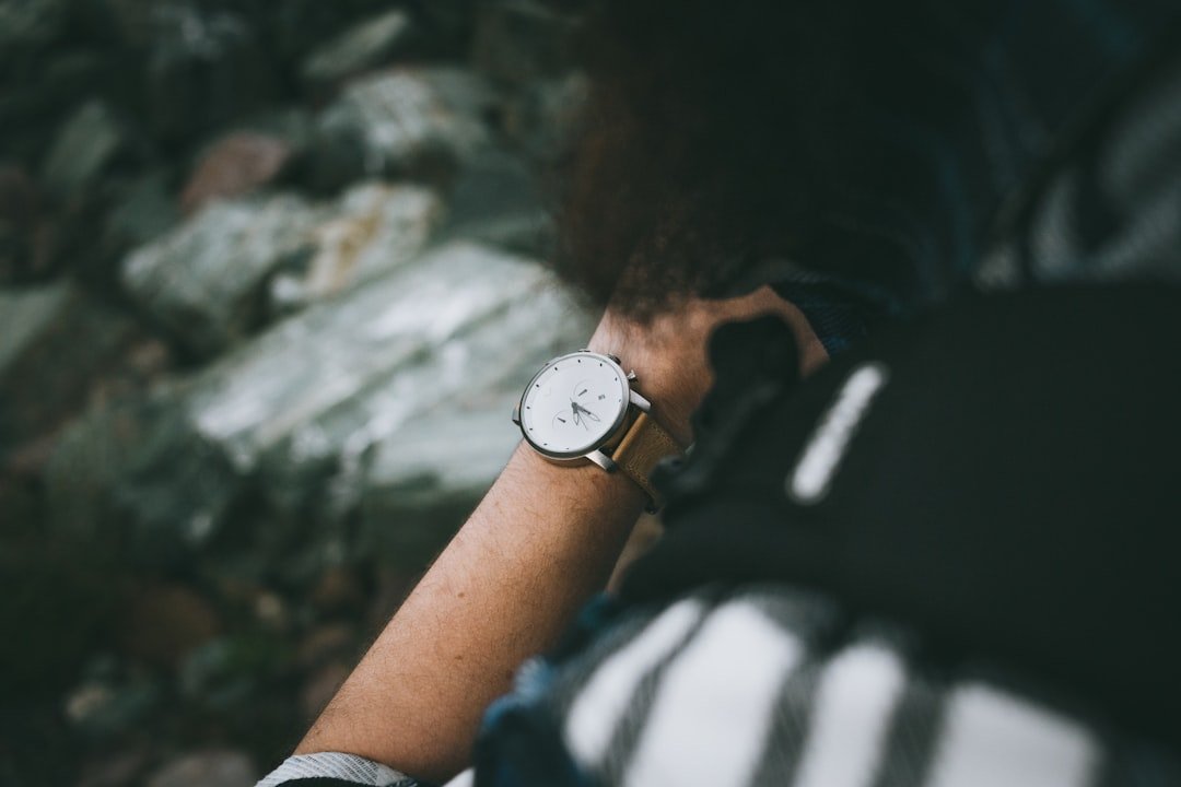 Person wearing silver round analog watch