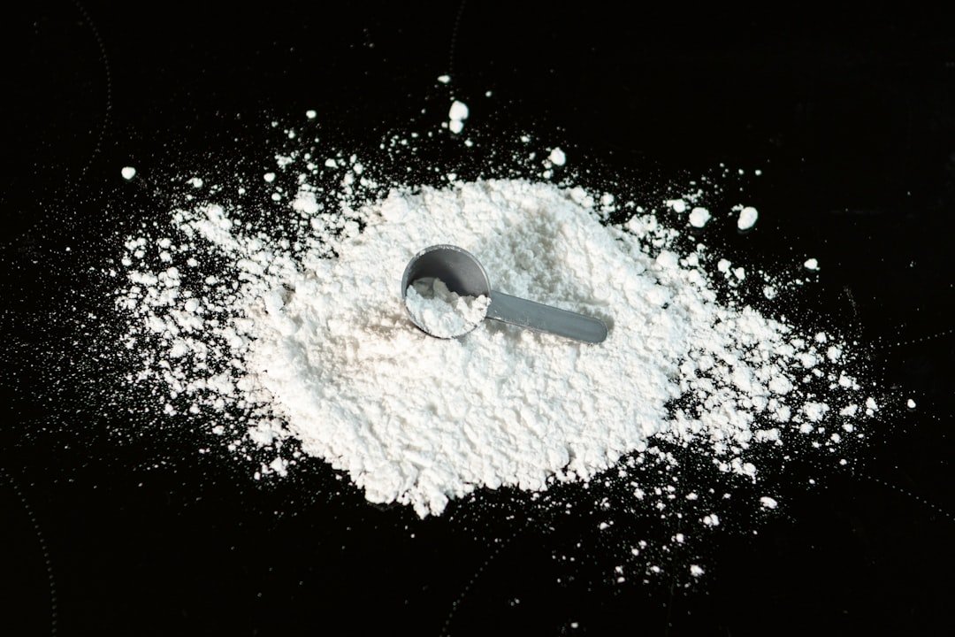 A scoop of powder next to a scoop of sugar