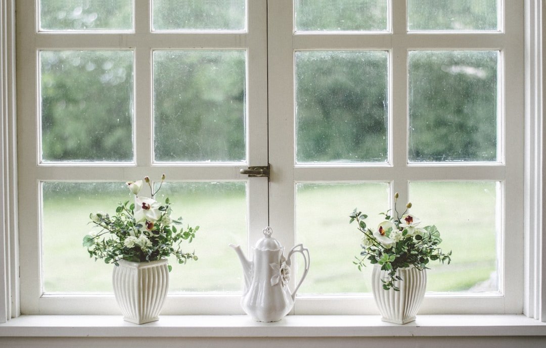 White teapot and tow flower vases on windowpane