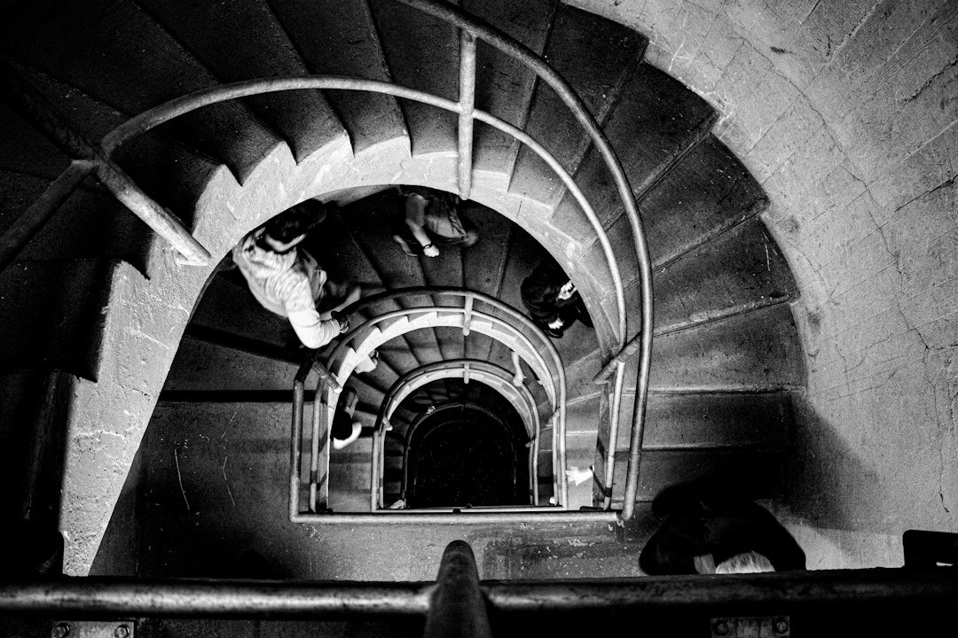 People descending a spiral staircase in a dark tower