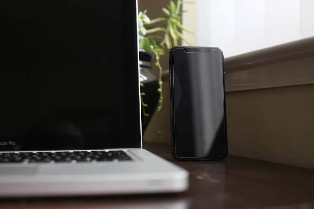 Black smartphone beside macbook pro