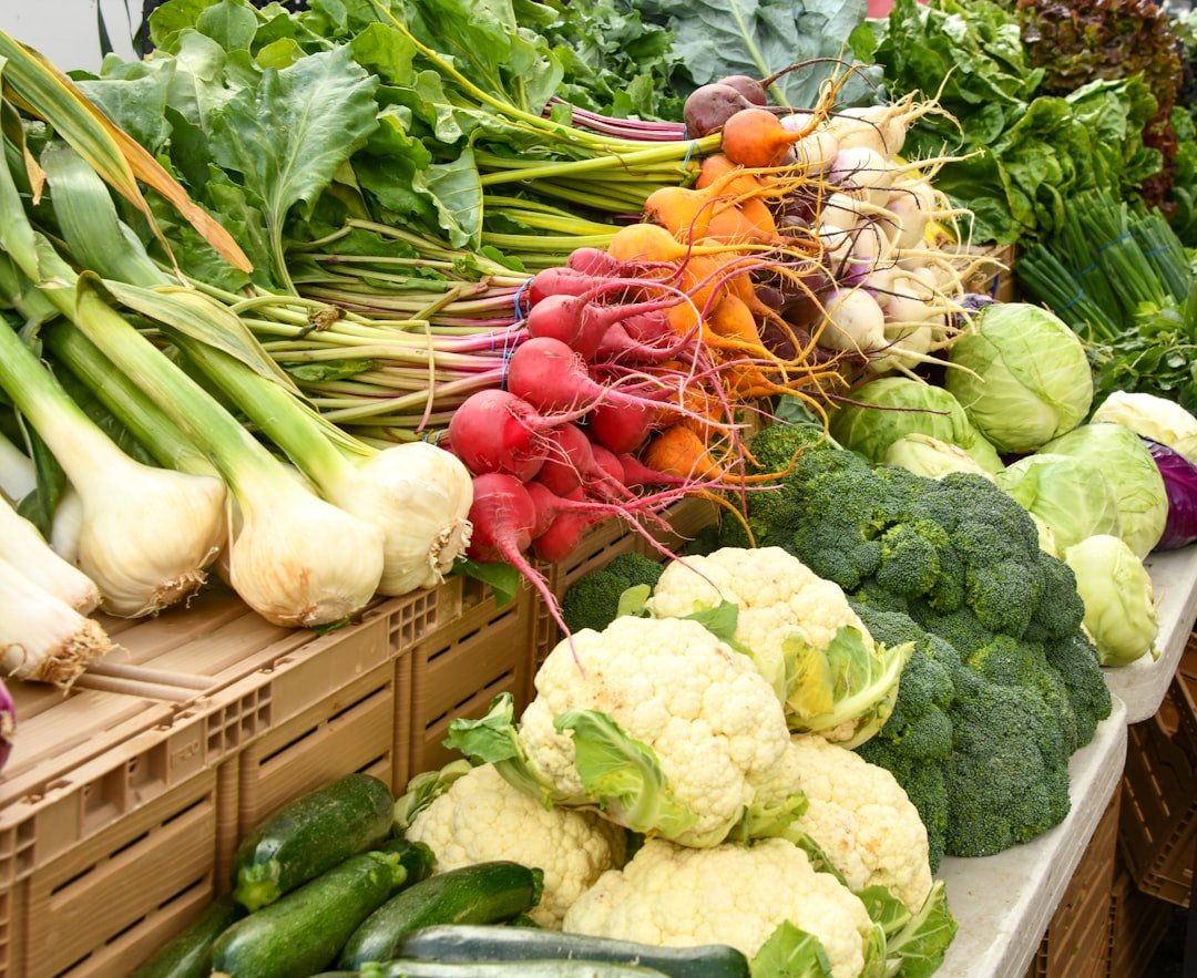 Fresh vegetables including cauliflower, broccoli, radishes, and onions on a market stall