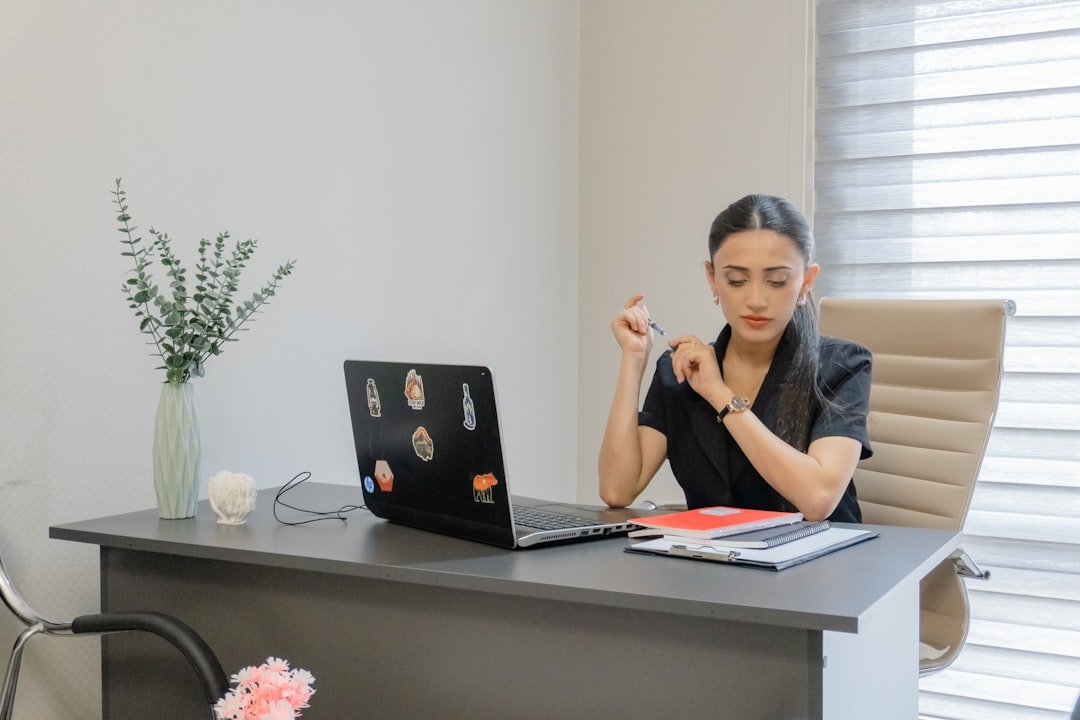 A woman works at a desk with a laptop