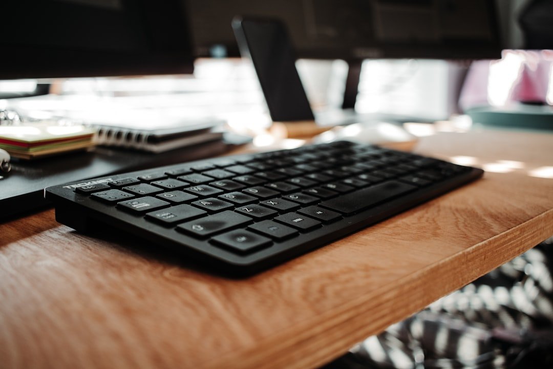 Black computer keyboard on brown wooden desk