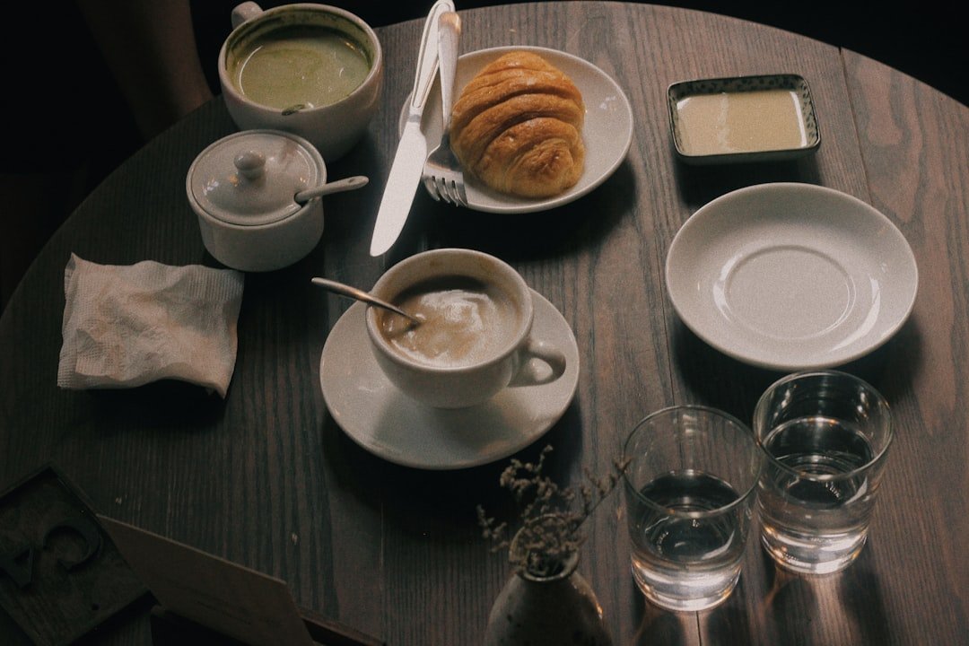 Cup of coffee and bun of bread on table