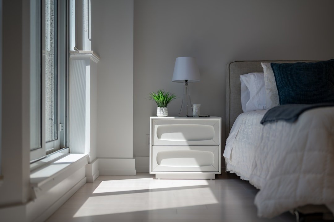 Sunlight illuminates a cozy bedroom with a bed and nightstand