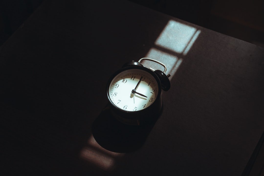 Alarm clock casting a shadow on a dark surface
