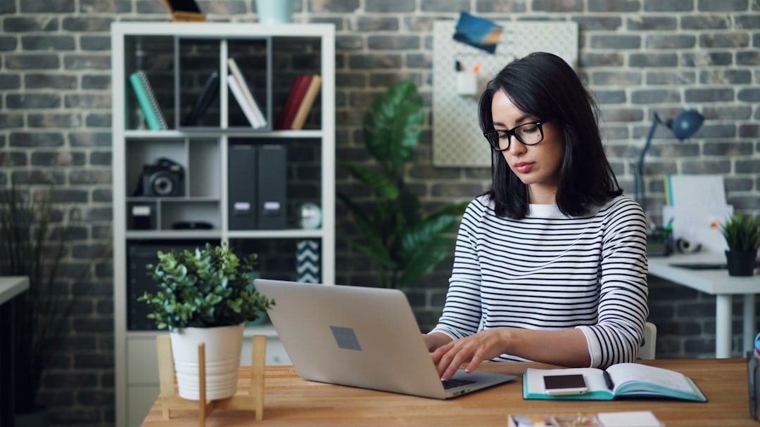 A woman sitting at a desk using a laptop computer