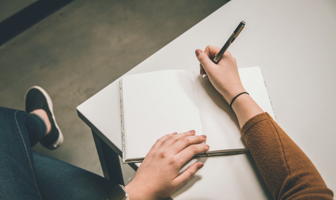 Person writing on white paper