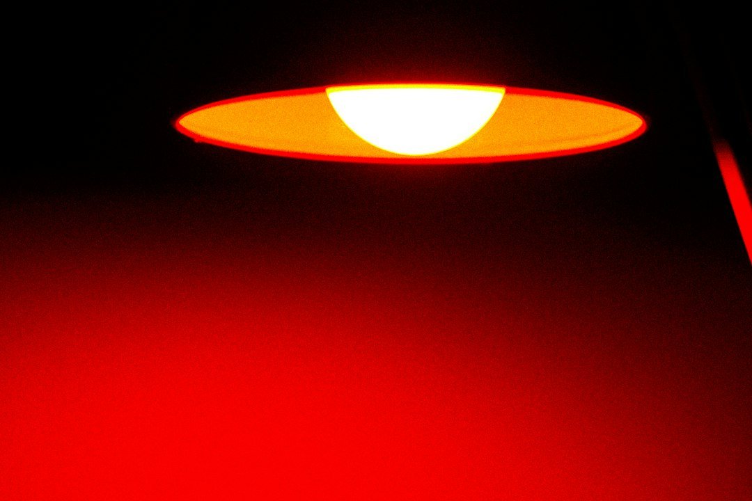 A glowing circular lamp casting a warm orange light against a dark background