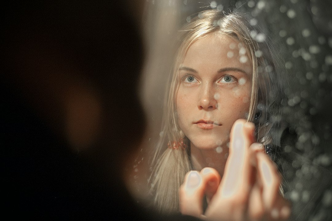 Woman with blonde hair holding her face